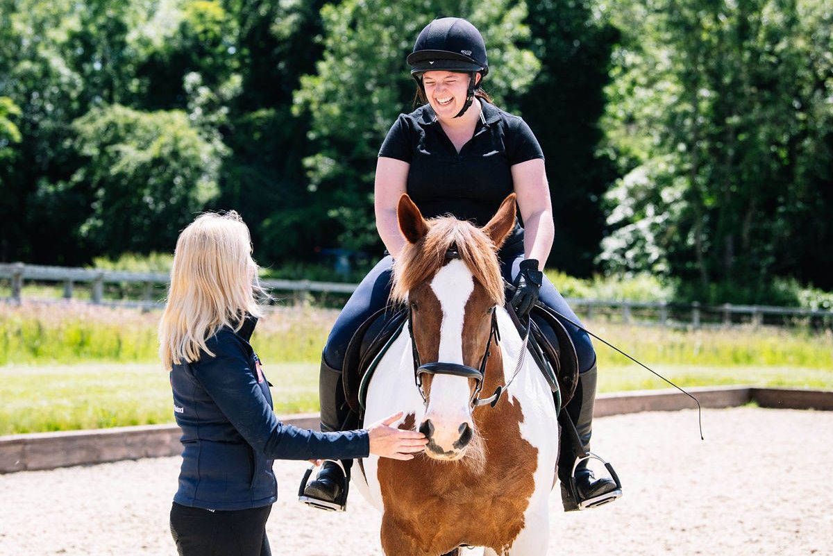 horse-rider-being-taught-by-a-riding-instructor-in-an-arena