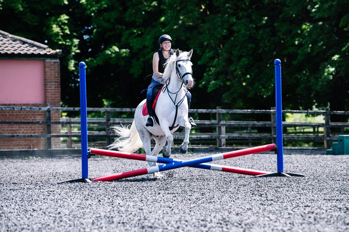 horse-rider-practicing-jumps-in-an-arena