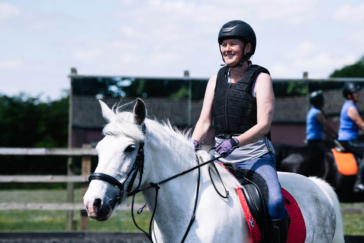 horse-rider-smiling-whilst-practicing-riding-their-horse-in-a-paddock